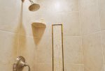 The guest bathroom features a custom designed shower with beautiful tile work